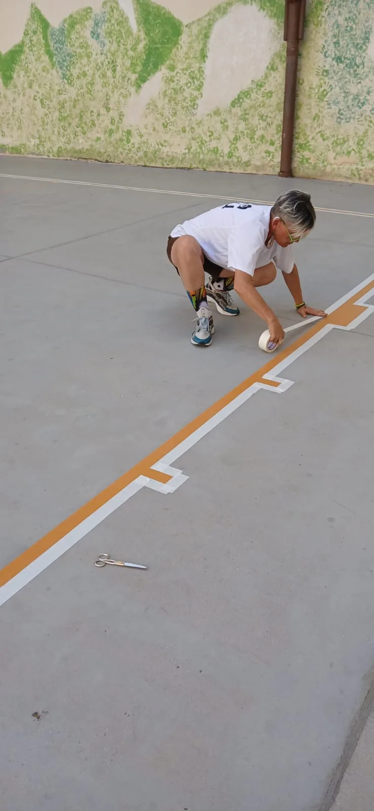 Voluntari pintant una línia taronja