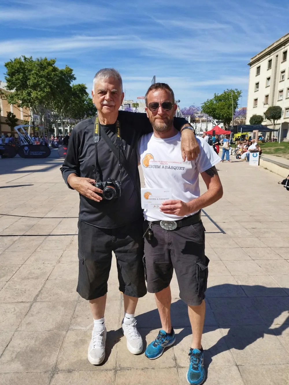 Miquel Àngel Forniés amb la seva càmera, acompanyat d'un membre de Juguem a Bàsquet